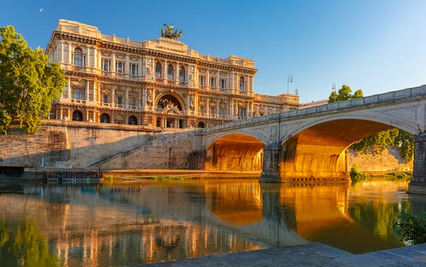 Palazzo di Giustizia and bridge over Tiber River in Rome at sunset.