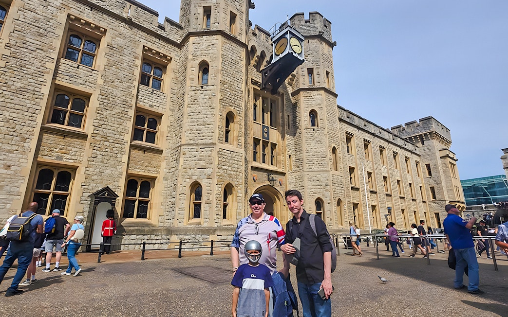 Visitors outside the historic Tower of London with a Yeoman Warder in the background.