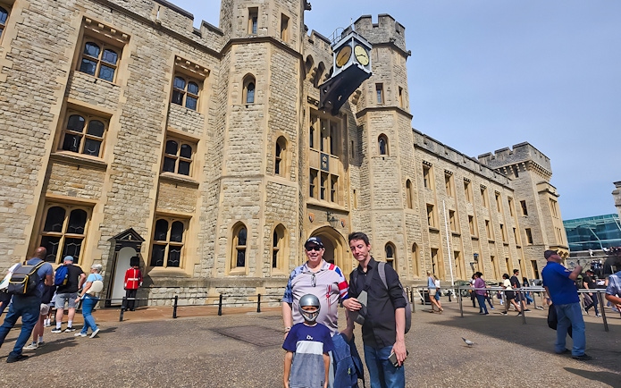 Visitors outside the historic Tower of London with a Yeoman Warder in the background.