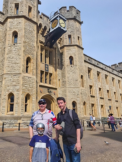 Visitors outside the historic Tower of London with a Yeoman Warder in the background.