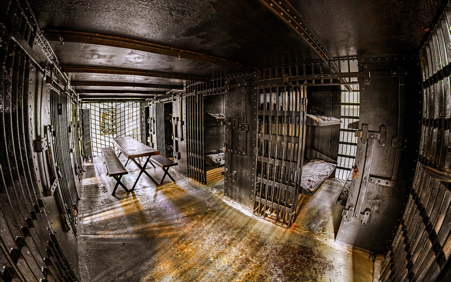 Interior of Old Jail with iron bars and wooden benches, Old Town Trolley, St. Augustine.