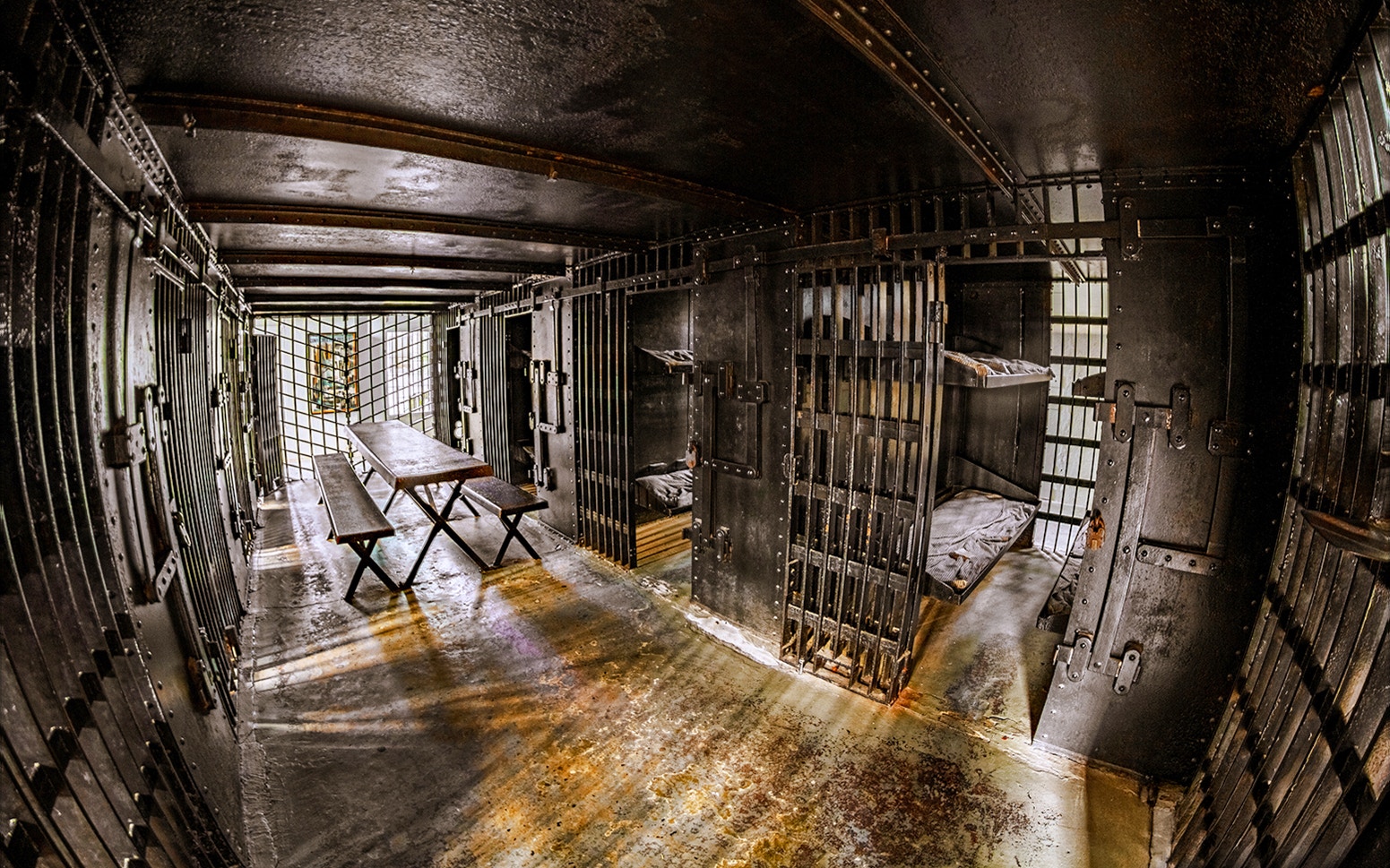 Interior of Old Jail with iron bars and wooden benches, Old Town Trolley, St. Augustine.