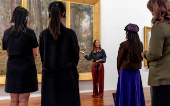 Tour guide explaining artwork to visitors at National Gallery of Victoria.