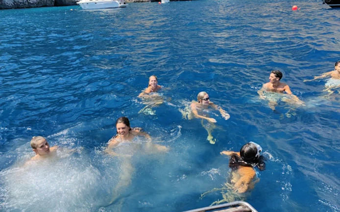 Swimming group enjoying Capri boat tour stop.