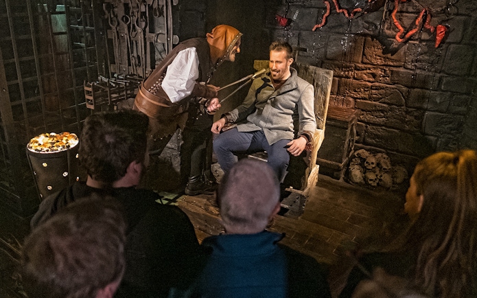 Visitor in torture chamber scene at London Dungeon's Scream Spirit experience.