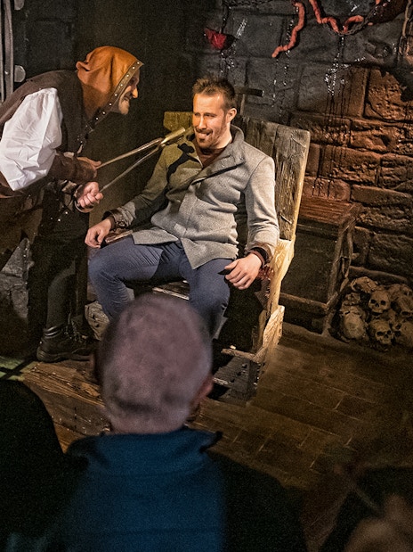 Visitor in torture chamber scene at London Dungeon's Scream Spirit experience.