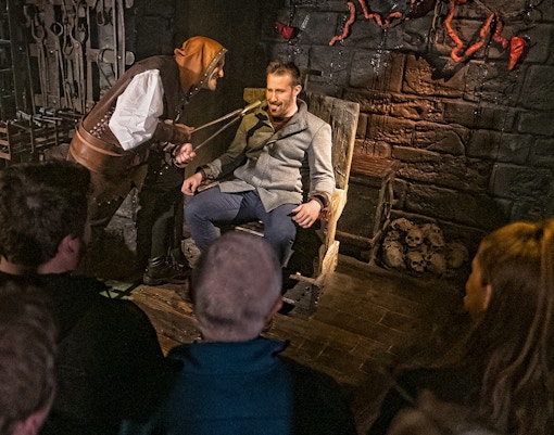 Visitor in torture chamber scene at London Dungeon's Scream Spirit experience.