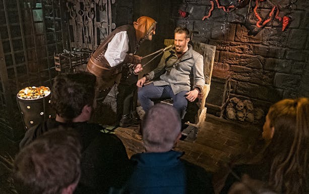 Visitor in torture chamber scene at London Dungeon's Scream Spirit experience.
