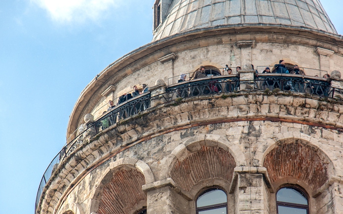 Visitors on the balcony of Galata Tower, Istanbul, viewing the cityscape.