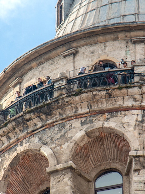 Visitors on the balcony of Galata Tower, Istanbul, viewing the cityscape.