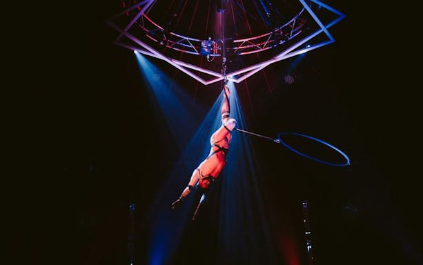 Aerial performer suspended from a hoop at Bite Club event.