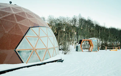 Geodesic dome in snowy forest during Snow and Fire Night experience.