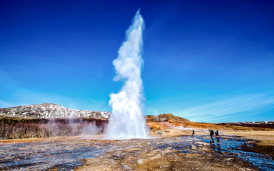 Geyser erupting in Icelandic landscape on Golden Circle tour from Reykjavik.