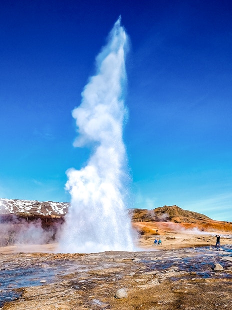 Geyser erupting in Icelandic landscape on Golden Circle tour from Reykjavik.