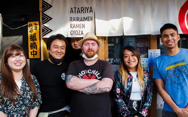 Group of people outside a ramen restaurant in Japan for a Ramen Kitchen Experience.