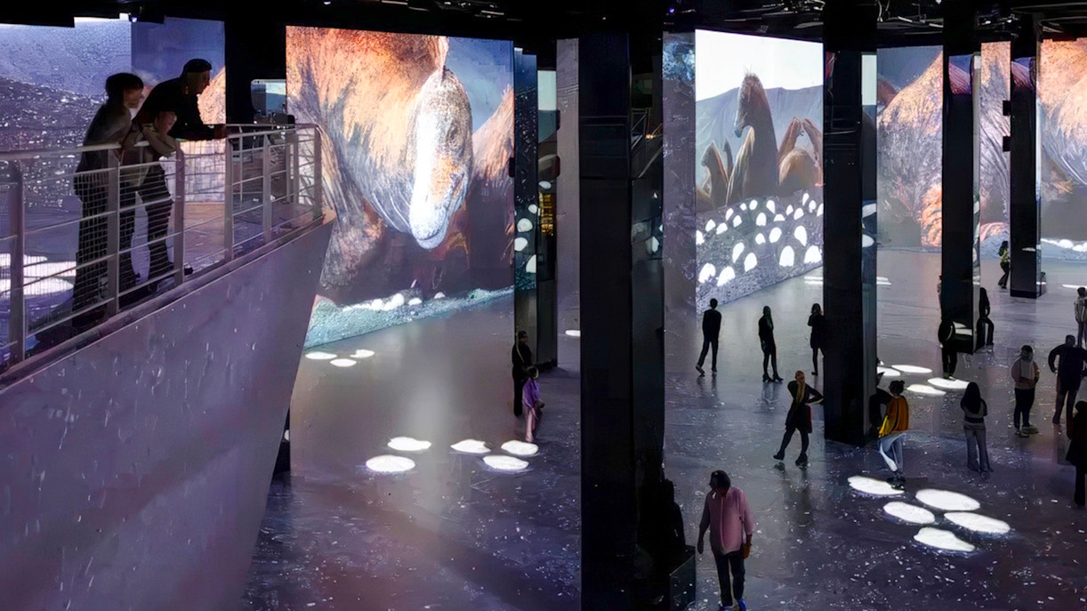 Guests exploring digital dinosaur displays at Phoenix des Lumières Dortmund exhibition.