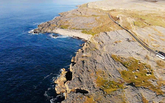 Aerial view of rocky coastline at The Burren, Ireland, meeting the Atlantic Ocean.