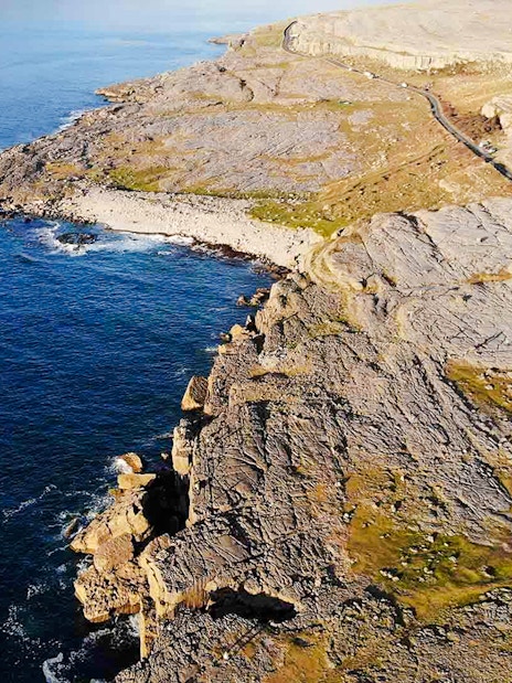 Aerial view of rocky coastline at The Burren, Ireland, meeting the Atlantic Ocean.
