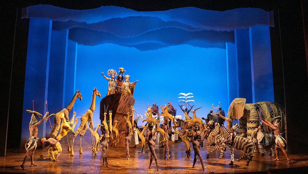 Stage performance of The Lion King in Brisbane with actors in animal costumes.