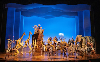 Stage performance of The Lion King in Brisbane with actors in animal costumes.