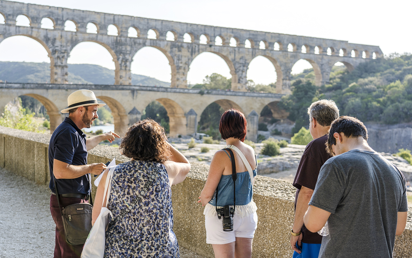 Tour group exploring Pont du Gard aqueduct in France.