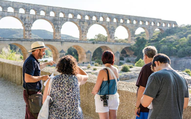 Tour group exploring Pont du Gard aqueduct in France.