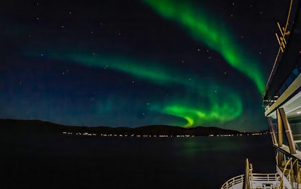 Northern lights over a cruise ship deck at night.