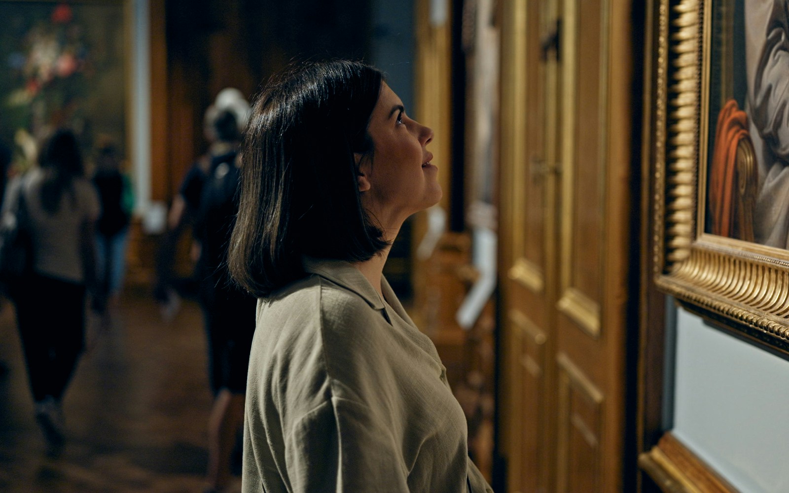 Visitor admiring paintings at a renowned art museum in Paris, France.
