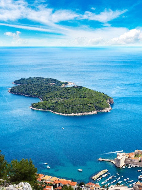 Lokrum Island in Dubrovnik, Croatia, surrounded by the Adriatic Sea with the city in the foreground.