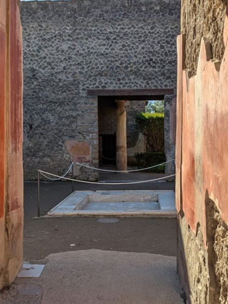 Ancient frescoed walls and courtyard in the ruins of Pompeii, Italy.