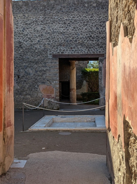Ancient frescoed walls and courtyard in the ruins of Pompeii, Italy.