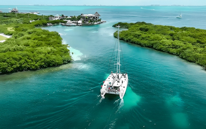 Catamaran sailing through turquoise waters from Cancun to Isla Mujeres.