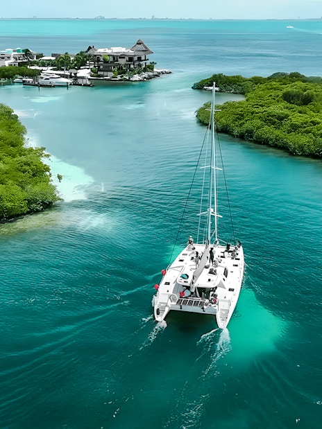 Catamaran sailing through turquoise waters from Cancun to Isla Mujeres.
