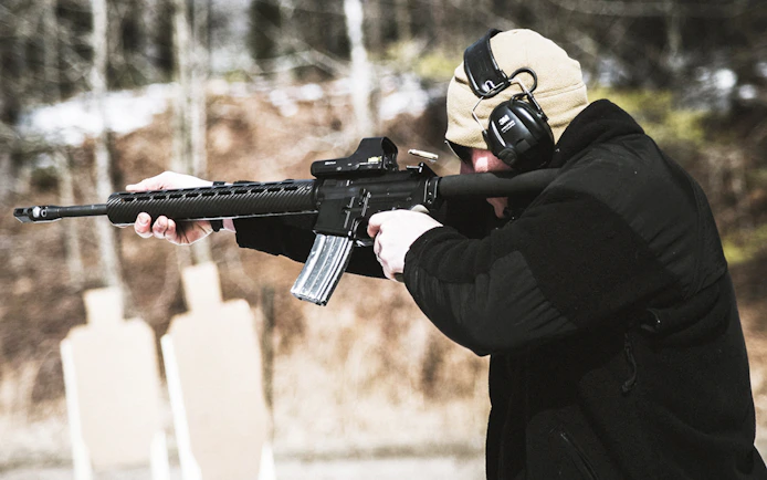 Person aiming rifle at targets at a shooting range in Krakow.