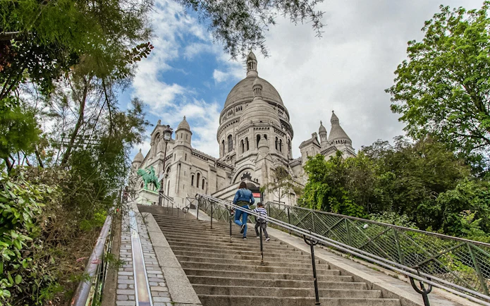 Visitors ascending steps to Sacré-Coeur Basilica in Montmartre, Paris.