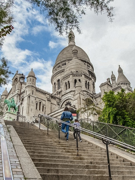 Visitors ascending steps to Sacré-Coeur Basilica in Montmartre, Paris.