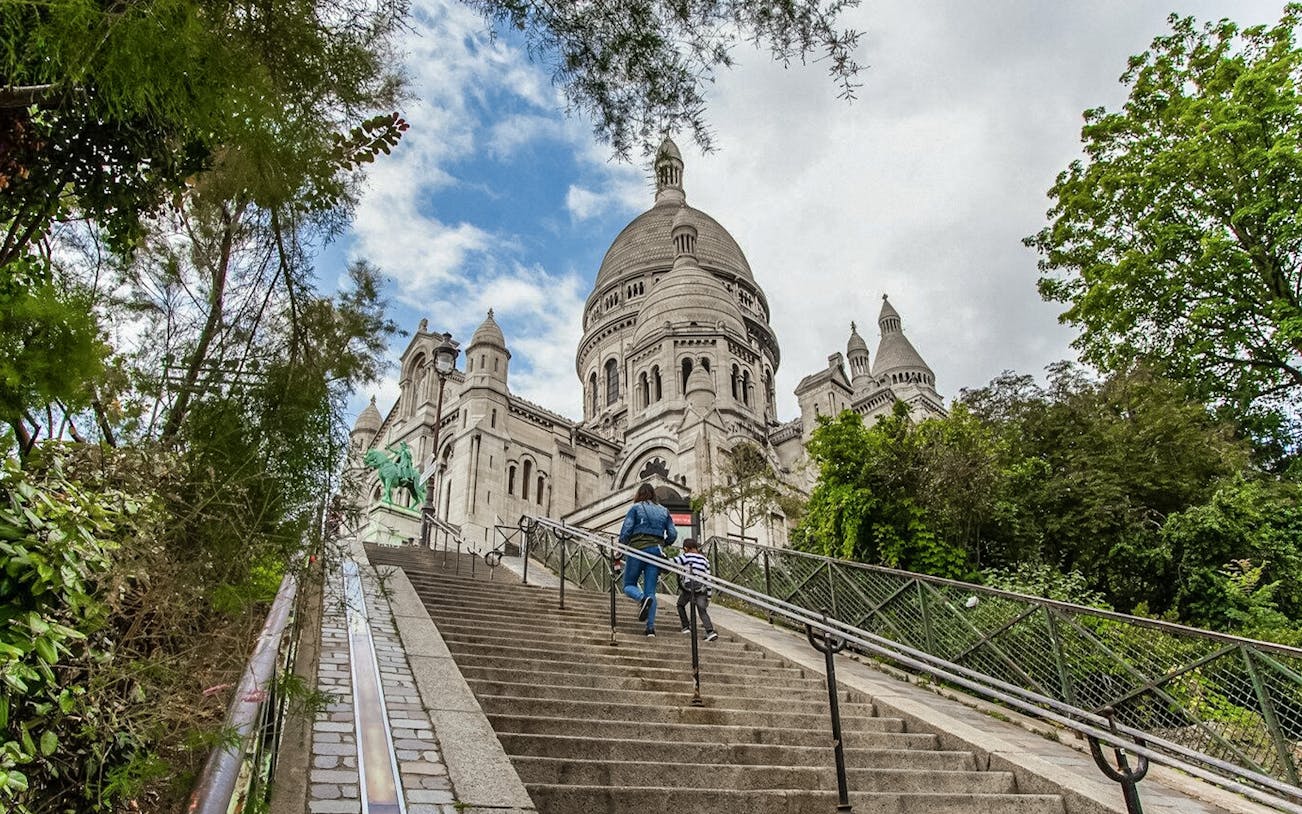 Visitors ascending steps to Sacré-Coeur Basilica in Montmartre, Paris.