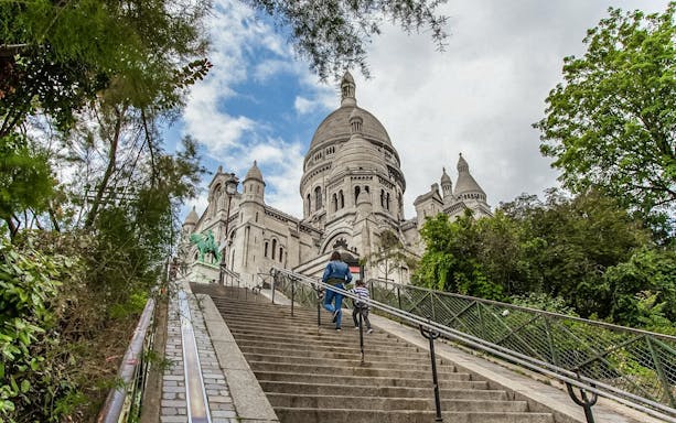 Visitors ascending steps to Sacré-Coeur Basilica in Montmartre, Paris.