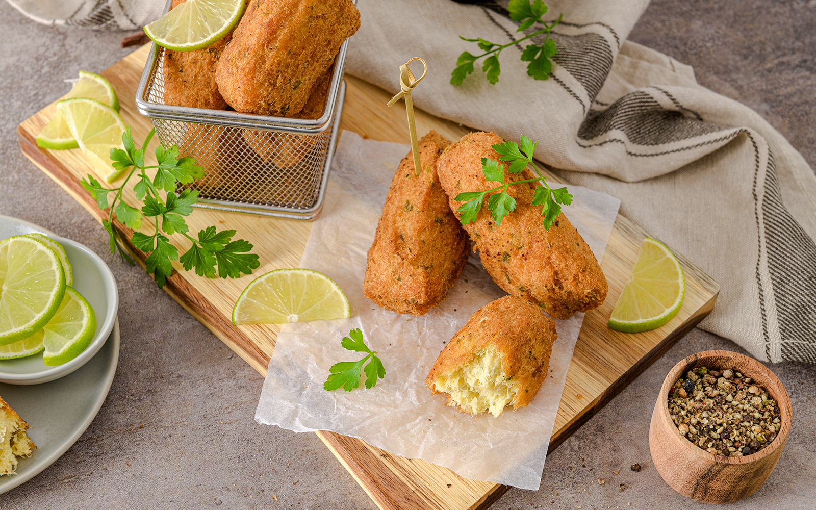 Golden cod cakes with lime slices on a wooden board, Douro Valley.