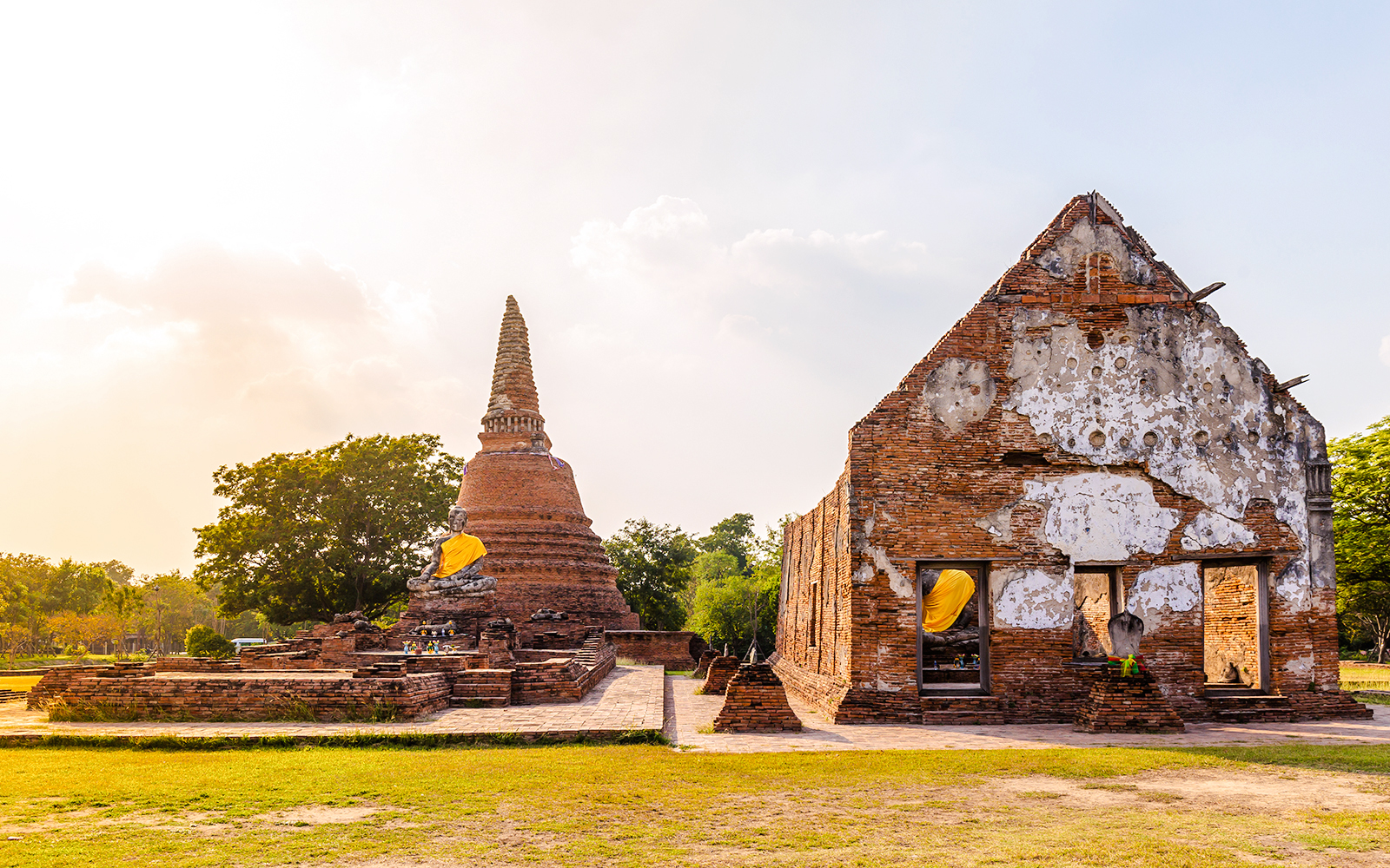 Wat Lokayasutharam complex with ancient brick ruins and reclining Buddha statue in Ayutthaya, Thailand.