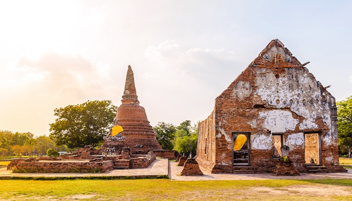 Wat Lokayasutharam complex with ancient brick ruins and reclining Buddha statue in Ayutthaya, Thailand.