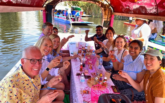 Group enjoying drinks on a boat tour through Aztec canals.