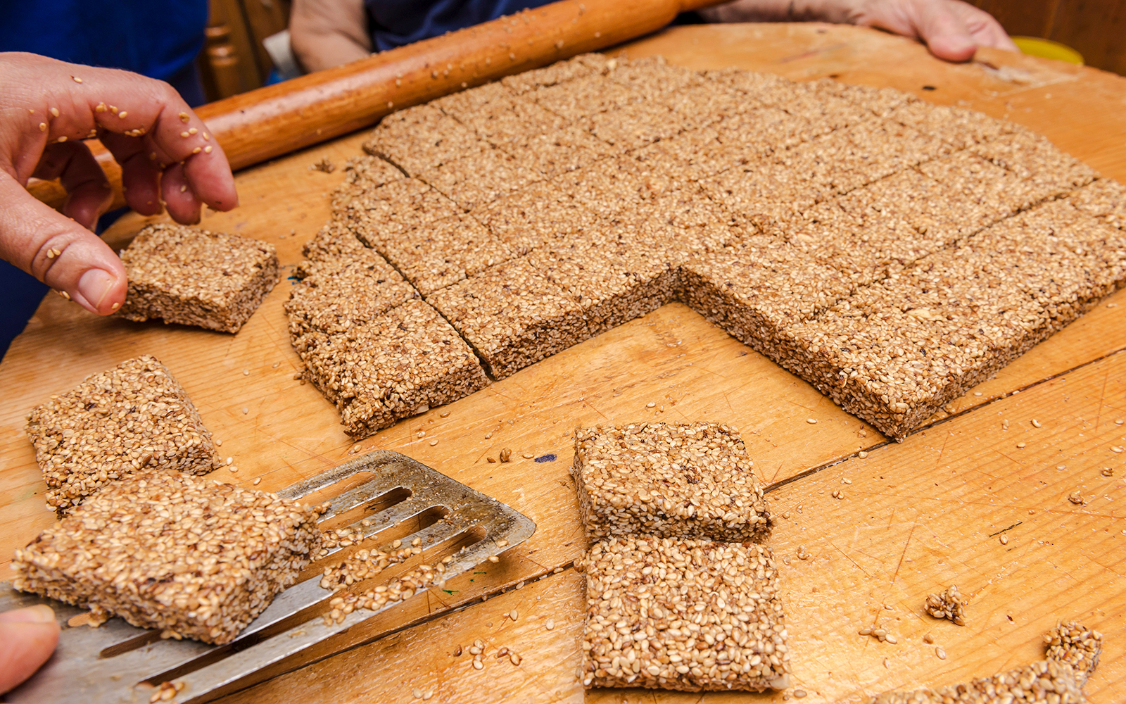 Melekouni sesame squares being prepared on a wooden board, Rhodes Island.