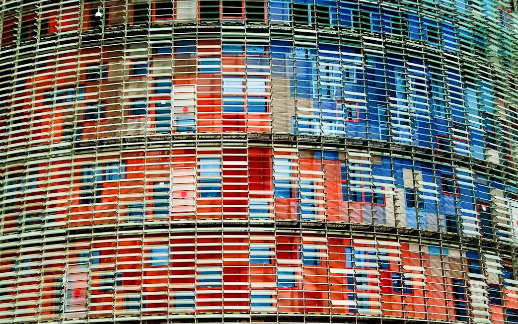 Facade of Torre Glories in Barcelona with colorful glass panels.