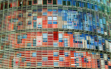 Facade of Torre Glories in Barcelona with colorful glass panels.