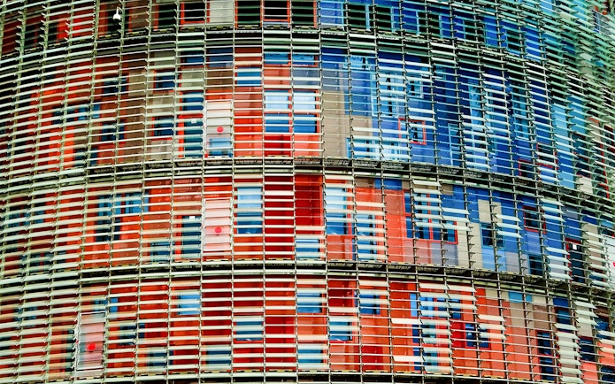 Facade of Torre Glories in Barcelona with colorful glass panels.