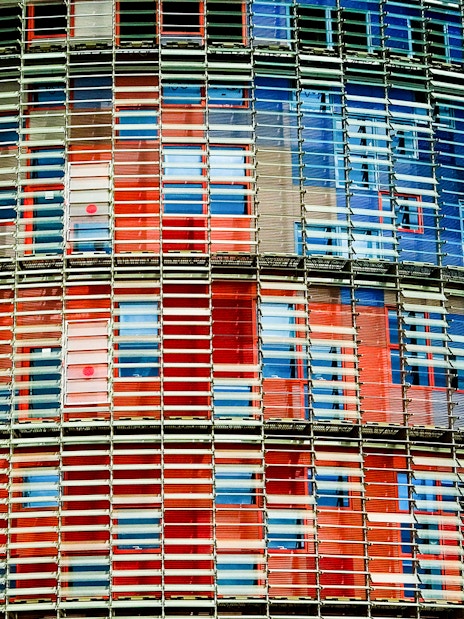 Facade of Torre Glories in Barcelona with colorful glass panels.