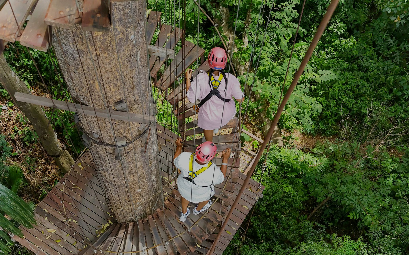 Visitors on a treetop platform at Hanuman World zipline adventure in lush forest.