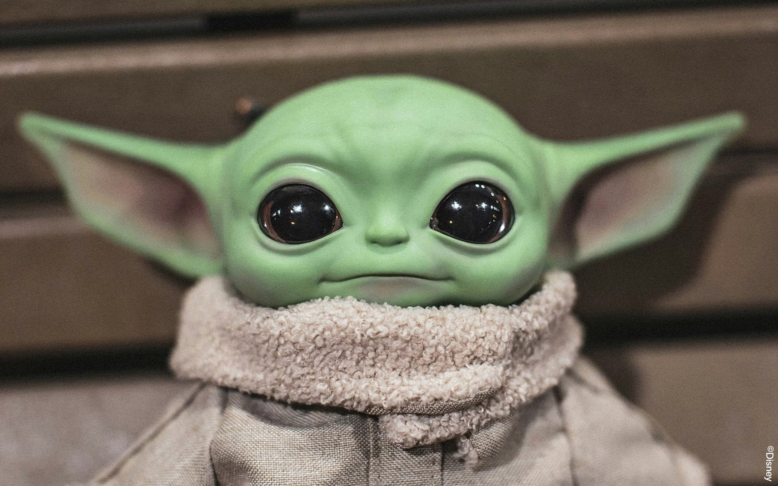 Grogu soft toy doll with green ears and large eyes.