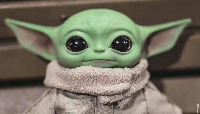 Grogu soft toy doll with green ears and large eyes.